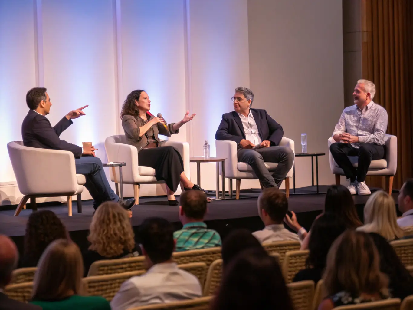 A professional photograph of a panel discussion at a startup conference in Edinburgh, with diverse panelists and a moderator.